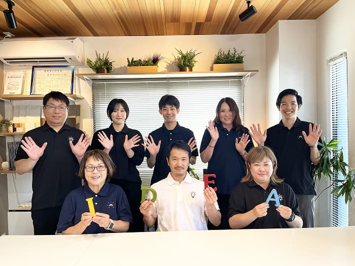 スタッフ全員で笑顔を見せる集合写真