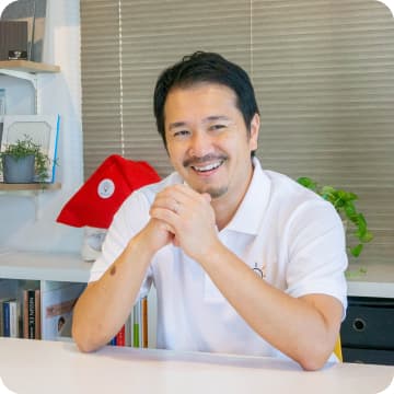 笑顔で指を指している男性スタッフ