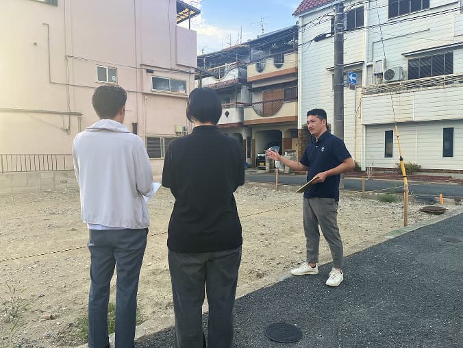 手の上に複数の間取り図が表示されたホワイトボード